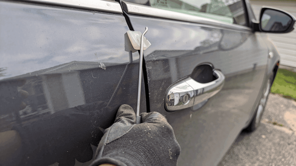 Professional non-destructive car entry tool at a vehicle door