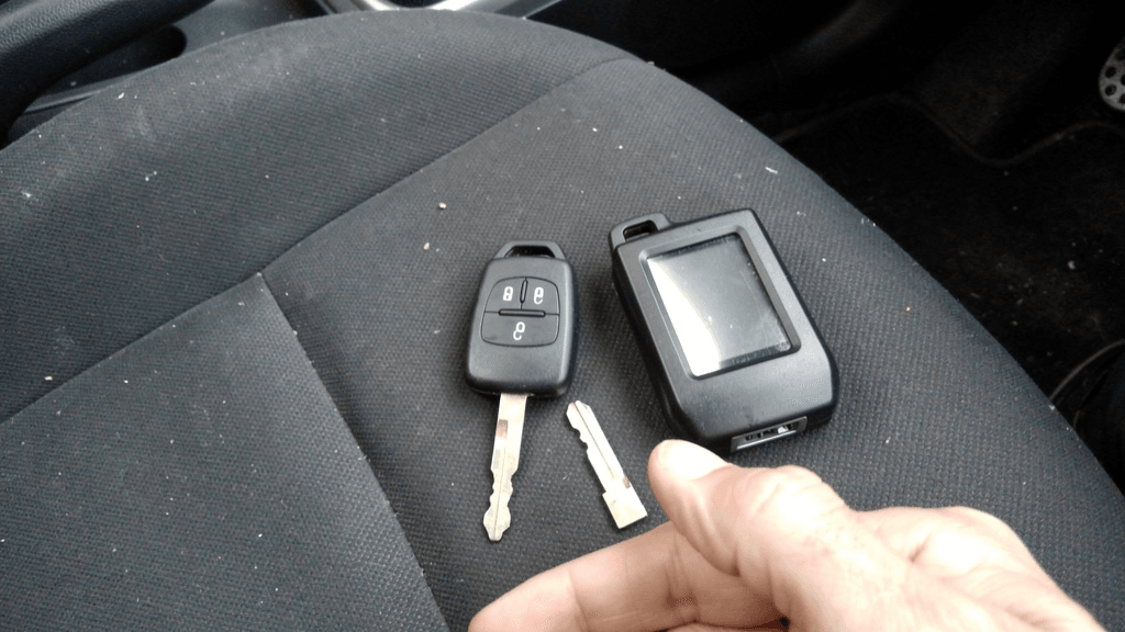 Unbranded modern vehicle key and programming tools inside a compact car