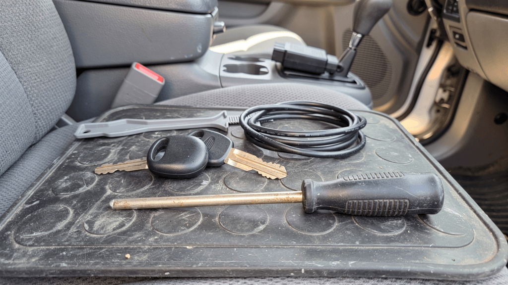 Unbranded remote key and programming cable beside a pickup-truck interior