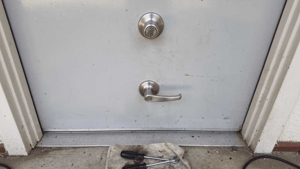 Residential entryway with a deadbolt, lever handle, and locksmith tools
