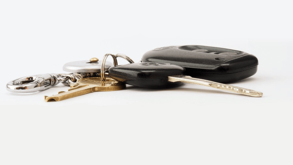 Real car keys and remote fob on a plain work surface