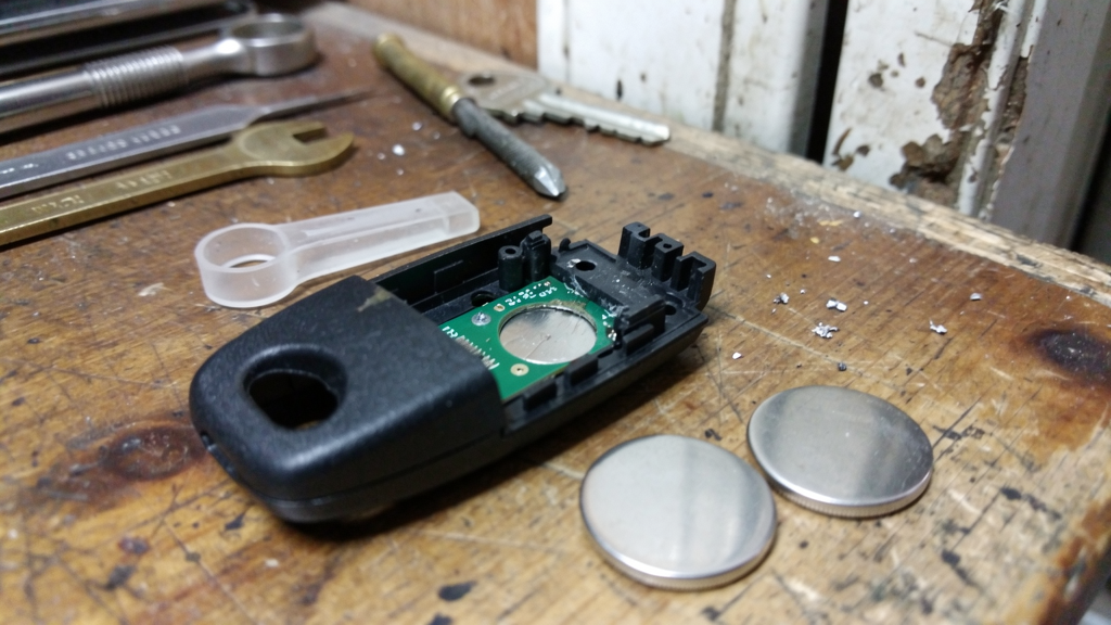 Open key fob and separate coin batteries on a workbench