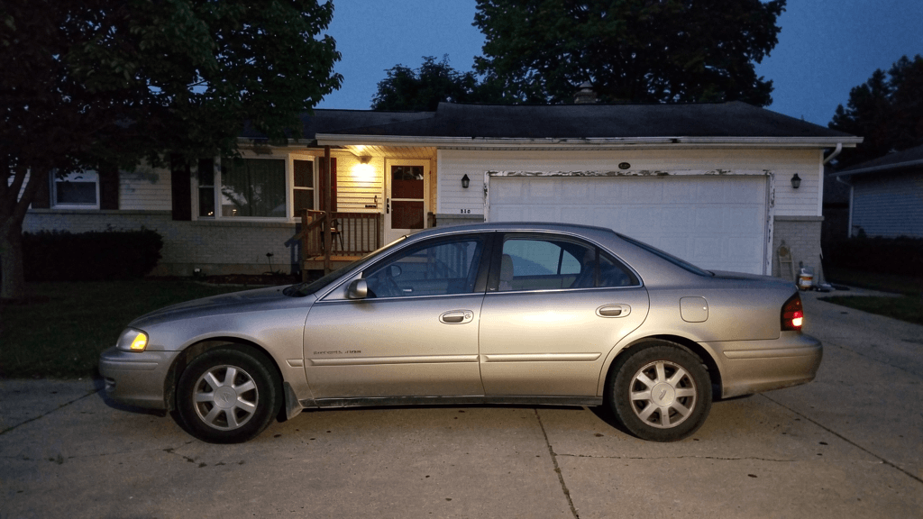 An unbranded car parked in a Peoria-area residential driveway at dusk