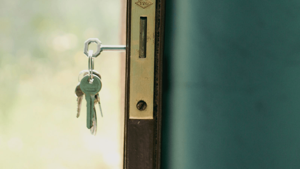 Real keys hanging from the lock of an open residential door