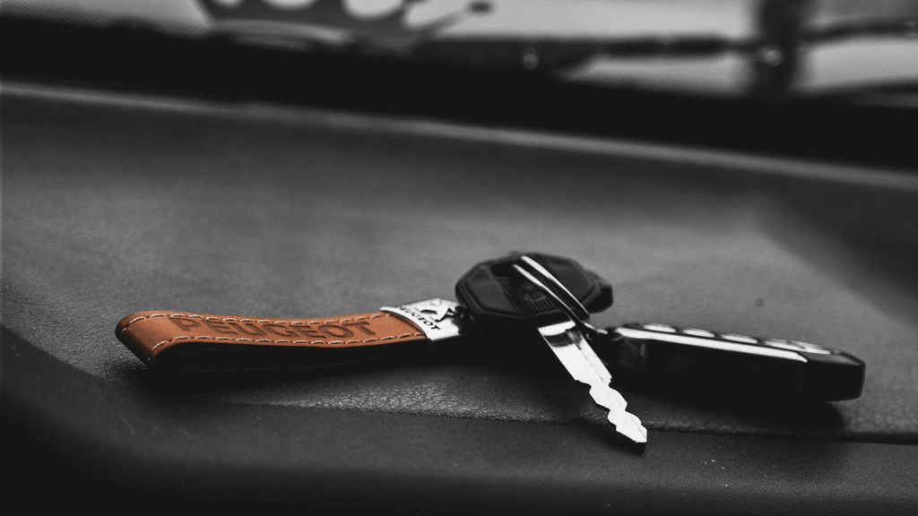 Real vehicle key and remote fob on a dark work surface